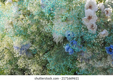 Delicate bouquet in white and blue tones. Gypsophila, white peonies, blue poppies