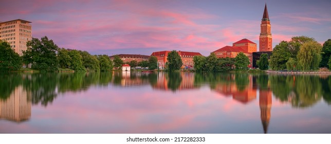: Kiel, Germany. Panoramic cityscape image of downtown Kiel, Germany with Town Hall, Opera House and reflection of the skyline in Small Kiel at sunset.
