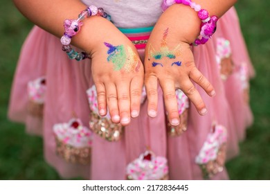 Shimmering sparkling glitter tattoo on a child's hand at a birthday party. Body art