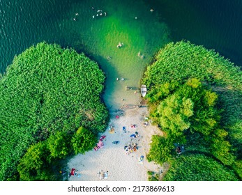 Vacaciones de verano en el lago verde. Descanso en la playa, tiempo libre. Vista aérea de una pequeña playa escondida rodeada de vegetación.