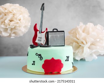 Bánh theo chủ đề âm nhạc với một cây đàn guitar trên đỉnh để trang trí. Đồ ăn ngọt cho sinh nhật của nhạc sĩ. Một món quà cho một người sáng tạo, một ca sĩ. Bất ngờ cho nghệ sĩ guitar. Nhìn từ trên xuống, không gian sao chép, cận cảnh.