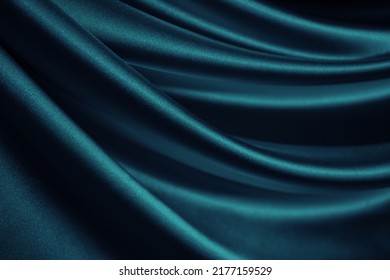 Cetim de seda verde azulado. Dobras onduladas suaves. Tecido sedoso brilhante. Fundo elegante de cor azul-petróleo escuro com espaço para design. Cortina. Drapeado. Conceito de Natal, dia dos namorados, aniversário, celebração.