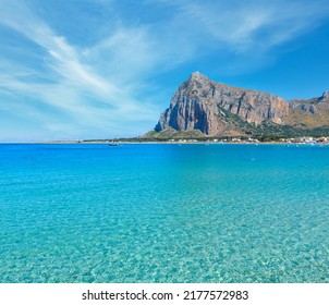 Teluk laut surga Tyrrhenian, pantai San Vito lo Capo dengan air biru jernih dan pasir sangat putih, dan Monte Monaco di jauh, Sisilia, Italia. Orang yang tidak bisa dikenali.