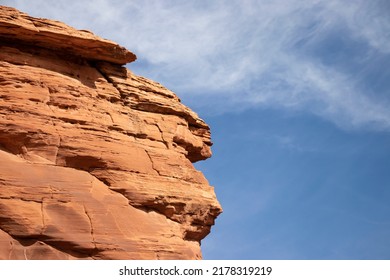 青い空を背景に茶色の岩。高い丘。オレンジ色の岩。