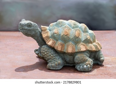 Steinschildkrötenskulptur sieht aus, als wäre er in Bewegung, bewacht aber stattdessen in glücklicher Stille den Garten