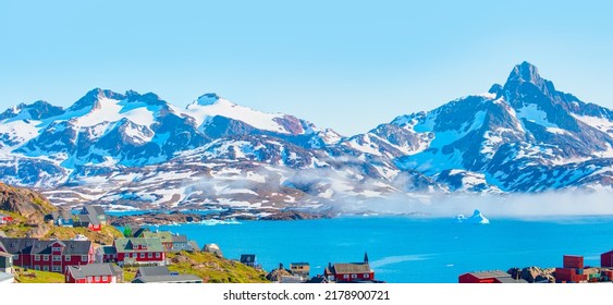 山と海の間に霧の層が広がる - グリーンランドの海岸にある絵のように美しい村とカラフルな家々 - 東グリーンランド、タシーラック