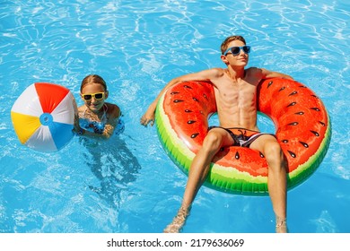 jongen en een meisje in zonnebril zwemmen in het buitenzwembad. Zomervakantie met kinderen. Zwemhulpmiddelen en kinderkleding. water speelgoed. Een klein kind drijft op een kleurrijk vlot