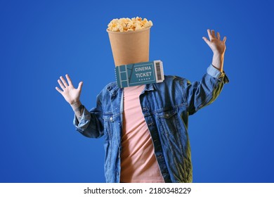 青の背景に彼の頭と映画のチケットの代わりにカリカリ ポップ コーンのバケツを持つ幸せな若い男