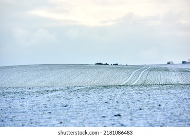 Paisaje de campo en un frío día de invierno con fondo de cielo nublado y espacio para copiar. Paisaje natural de un campo agrícola, prados o pastos cubiertos de nieve blanca en una brillante mañana nublada