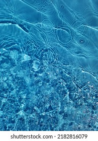 Defocus wazig blauw water schijnt in de zee. golfde water detail achtergrond. Het wateroppervlak in de zee, oceaan achtergrond. Watergolf onder overzeese textuurachtergrond.