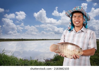大きな魚を保持しているアジアの漁師。