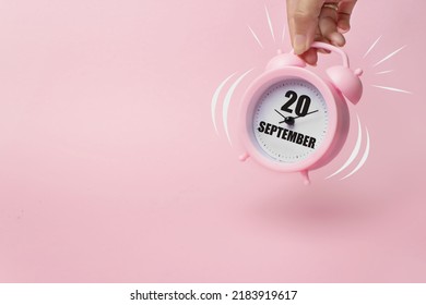 9月20日。月の 20 日、カレンダーの日付。ピンクの背景にカレンダーの日付でベルから飛び上がる朝の目覚まし時計。秋の月、年のコンセプトの日