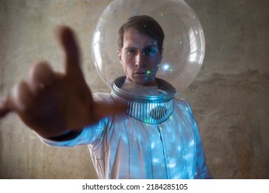 An astronaut on a desert planet alone, an explorer on a distant planet, other worlds and civilizations. A young man in a retrofuturism-style white spacesuit stands on the sand and looks around