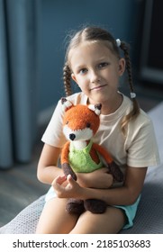 a girl of eight years old plays with knitted toys in the room