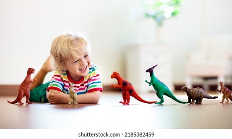Bambino che gioca con dinosauri giocattolo colorati. Giocattoli educativi per bambini. Bambino che impara a conoscere fossili e rettili. Bambini che giocano con i dinosauri giocattolo. Gioco di evoluzione e paleontologia per bambini piccoli.