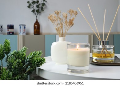 pencahayaan mewah lilin beraroma aromatik ada di atas meja logam putih dengan vas keramik dan reed diffuser untuk menciptakan suasana santai di kamar tidur dengan latar belakang kamar tidur dan tirai yang bagus di hari Valentine