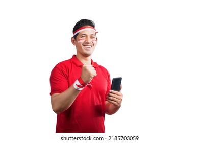 Pria Indonesia merayakan hari kemerdekaan Indonesia pada 17 Agustus sambil memegang ponsel terisolasi di atas latar belakang putih