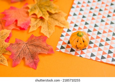 Foto labu, daun musim gugur, kertas Chiyogami dan latar belakang oranye