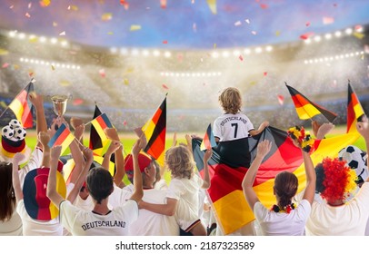Germany football supporter on stadium. German fans on soccer pitch watching team play. Group of supporters with flag and national jersey cheering for Germany. Championship game. 