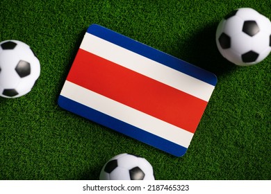 コスタリカの国旗。緑の芝生の上のサッカー ボール。2022 年ワールド カップ。トップ ビュー。