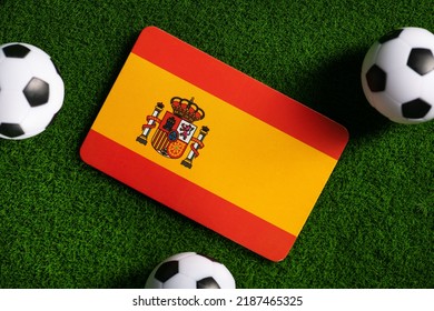 スペインの国旗。緑の芝生の上のサッカー ボール。2022 年ワールド カップ。トップ ビュー。