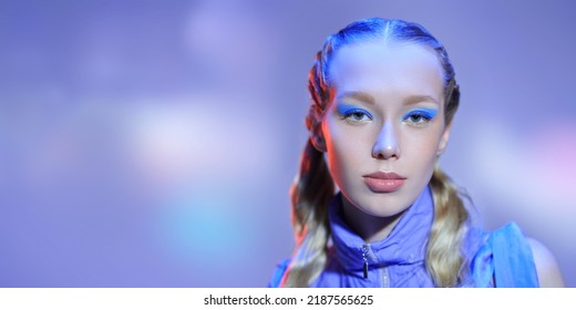 Belleza, maquillaje y cosmética. Retrato de una hermosa chica con cabello rubio ondulado y maquillaje de ojos turquesa posando sobre un fondo morado. Copie el espacio.