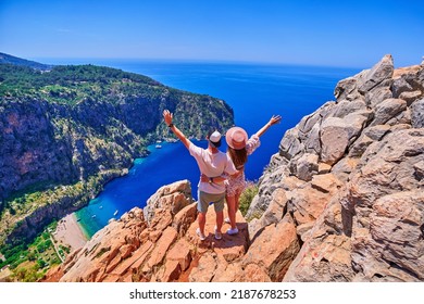 Liefhebbers paar reiziger staat samen op heuvelrots over blauwe zee baai in Turkije, vlindervallei. Geniet van vakantie vakantie en mooie reisbestemmingen