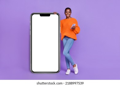 Foto in voller Länge eines jungen hübschen Mädchens, das Kommentar zum Download einer mobilen App verwendet, isoliert auf violettem Hintergrund