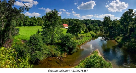 緑に囲まれた川の夏のパノラマ。夏の川。夏の川のパノラマ風景。夏の田園パノラマの川