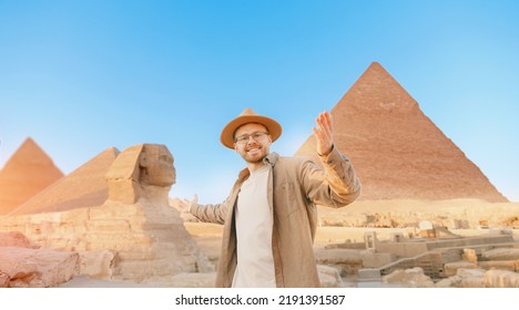 Travel man in hat background pyramid of Egyptian Giza and Sphinx, sunset Cairo, Egypt.