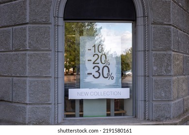 碑文のある店の窓: 10%、20%、30% オフ、新しいコレクション。割引。販売