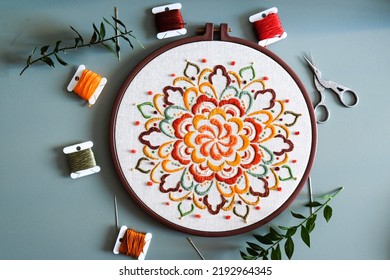 Mandala-Muster-Design-Stickerei, faarweg Mandala-Design, handgemaachten Stickereidesign, Stickgaren, Nadelbastelen, flaache Schreifdësch, gréngen Hannergrond, Vue vun uewen mat Garen, Konzept fir kleng Geschäftsleit.