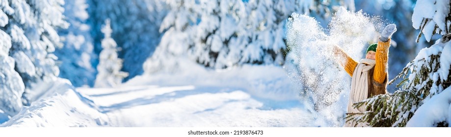 Happy little girl playing with snow throwing up snowflakes. Love winter concept. Heart from scattered snowflakes.