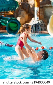 Papa übergibt seine Tochter, sie haben Spaß und spielen zusammen im Pool. Schwimmtraining. Urlaub mit Kindern. Vatertag. Vaters Liebe und Fürsorge. Familienurlaub mit Kindern.