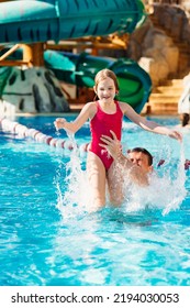 Papa übergibt seine Tochter, sie haben Spaß und spielen zusammen im Pool. Schwimmtraining. Urlaub mit Kindern. Vatertag. Vaters Liebe und Fürsorge. Familienurlaub mit Kindern.