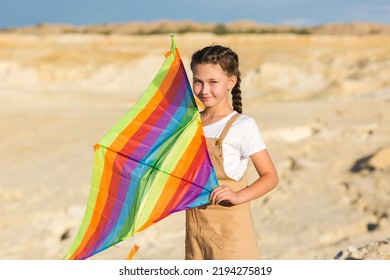 Girl with a kite in her hands background of mountains and desert.