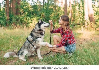 tienermeisje spelen en plezier maken met haar Siberische husky hond. Meisje met hond in het bos