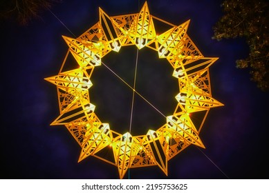 Symmetric yellow star (tetradecagon or fourteen sided polygon) shining with bright golden light in the night sky. 14 gon shape fluttering in a dark sky conveys spiritual, solemn meaning. Hope concept