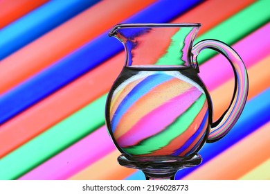 Ilusión óptica creada al refractar la luz con una jarra de agua y líneas diagonales de colores