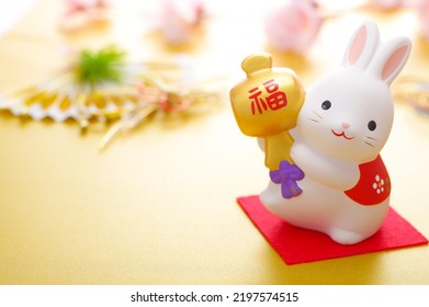 Thiệp chúc mừng năm mới con thỏ. Phiên bản ngang. Con thỏ đang cầm một cái vồ nhỏ trên đó có viết chữ "FUKU" bằng tiếng Nhật.