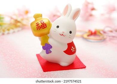 Kartu ucapan tahun baru untuk tahun kelinci. Versi horisontal. Kelinci itu memegang palu kecil yang bertuliskan "FUKU" dalam bahasa Jepang.