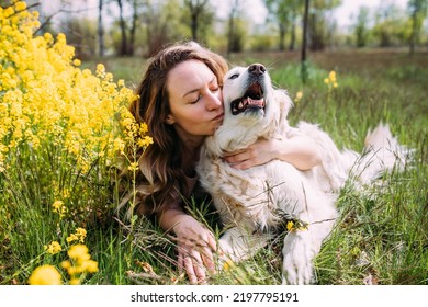 Giovane bella donna e il suo cane golden retriever si divertono in estate