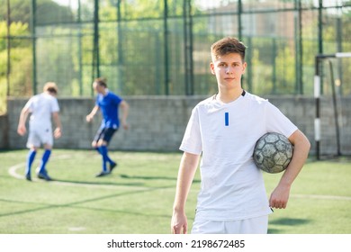 Junior voetballer staande op veld met bal