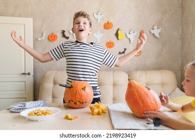 A boy cuts a pumpkin for Halloween and have fun.