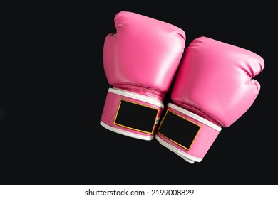 pink boxing gloves for girl and woman fight with copy space in dark background.