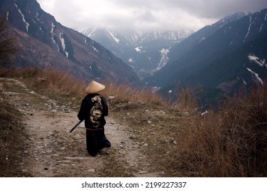 曇りの天候で山道を歩く着物に描かれたドラゴンとサムライに扮した少年の後姿