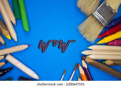 Overhead shot van schoolbenodigdheden met Wow-tekst. Borstels, potloden, artistieke gereedschappen. Kunst En Ambachtelijke Werkgereedschappen.