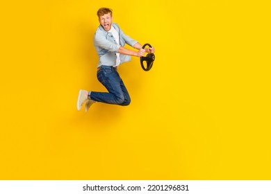 不注意なハンサムな男青いシャツ ジーンズ スニーカーの完全な長さの写真は黄色の背景に分離されたステアリング ホイールを保持します。