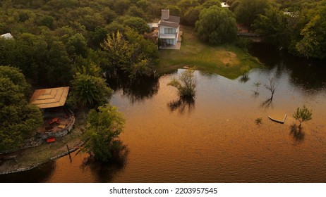 Casa en la orilla del río al atardecer, cerros de Córdoba en Argentina