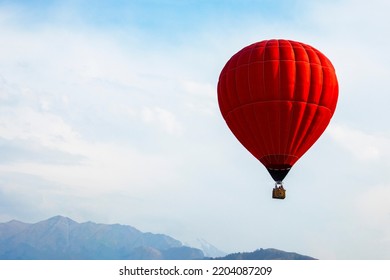 grote rode ballon boven bergtoppen in bewolkte lucht